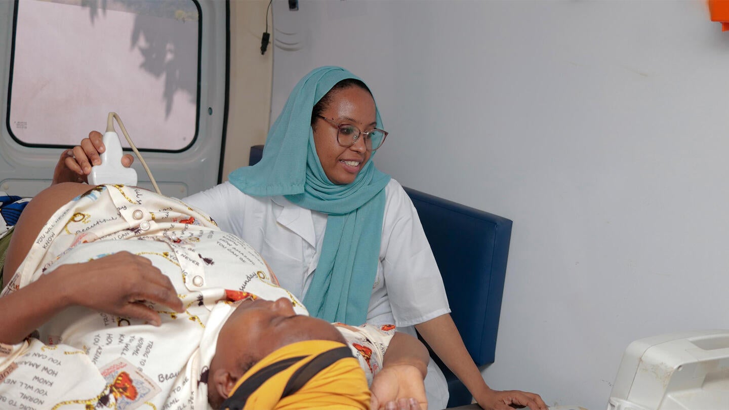 une femme enceinte entrain de passer une échographie dans la clinique mobile. 